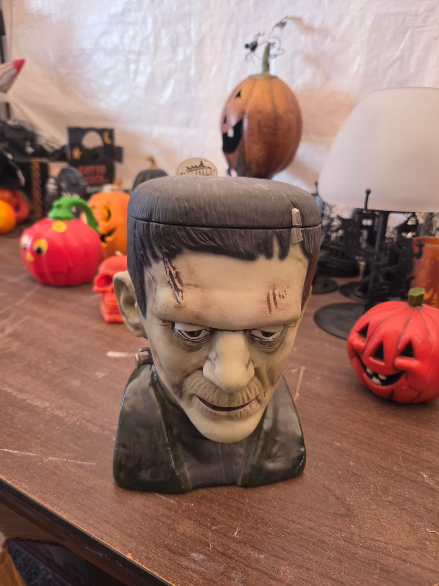 Vintage Frankenstein cookie jar with jack-o'-lanterns and Halloween decor